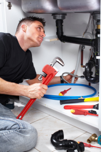 a strong service tech prepares to remove the drain seal from a leaky sink
